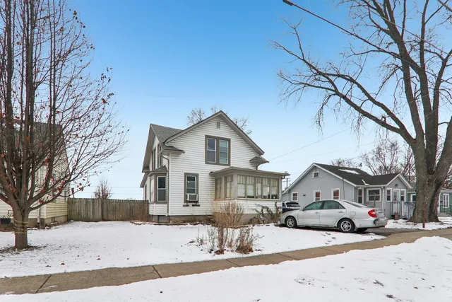 a front view of a house with a yard covered in snow
