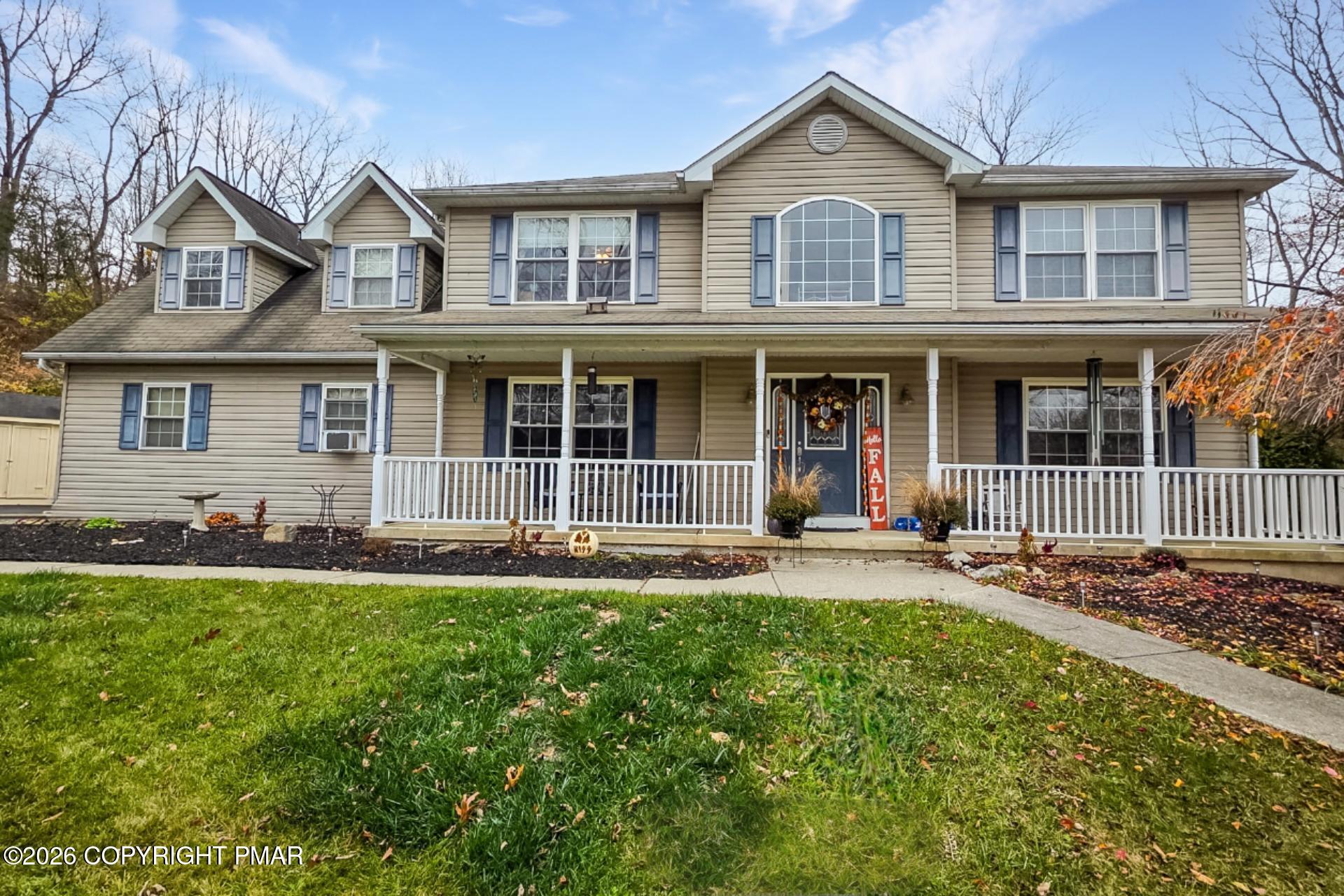 a front view of a house with a yard and outdoor seating
