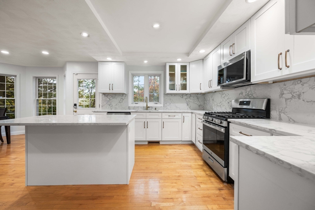 772 Main Street, Unit 2 Wakefield, MA 01880 - Photo 1 of 30 a kitchen with stainless steel appliances a sink dishwasher a stove top oven a refrigerator with white cabinets and a wooden floor