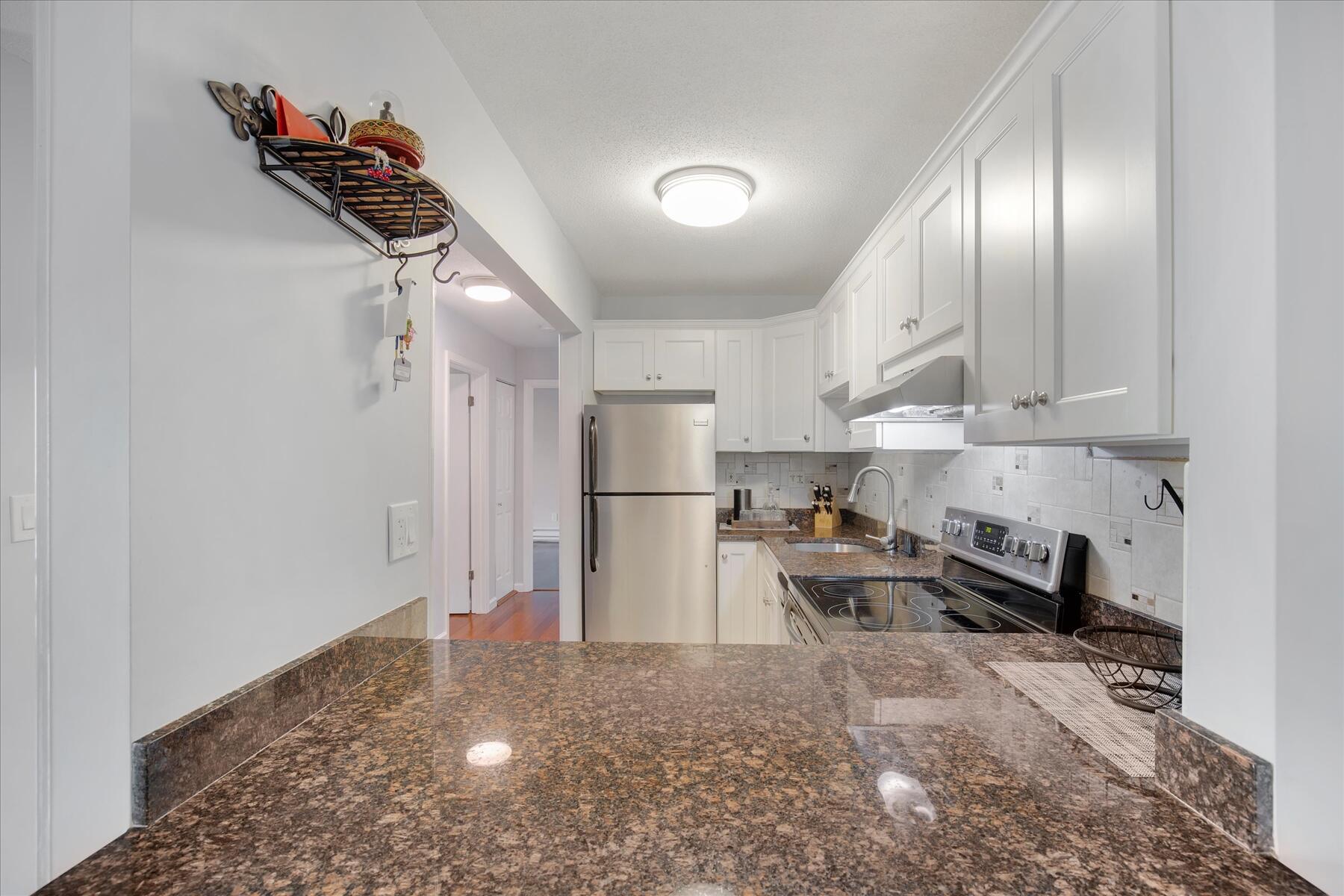 800 Bearses Way, Unit 1EB Hyannis, MA 02601 - Photo 12 of 37 a kitchen with stainless steel appliances granite countertop a refrigerator and a stove