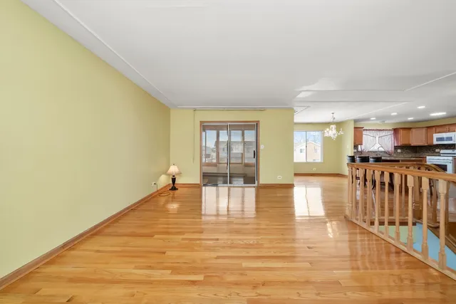 a view of empty room with wooden floor and floor to ceiling window