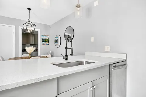 a kitchen with kitchen island granite countertop a sink and a wooden floor