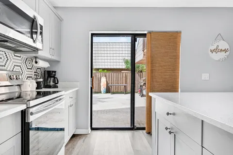 a kitchen with stainless steel appliances cabinets and wooden floor