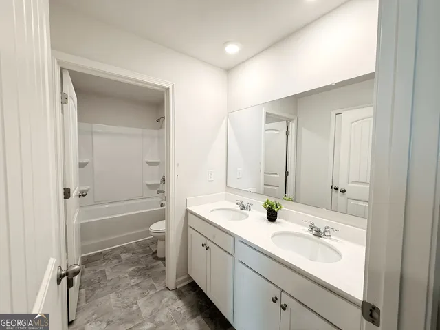 a bathroom with a tub a sink and mirror