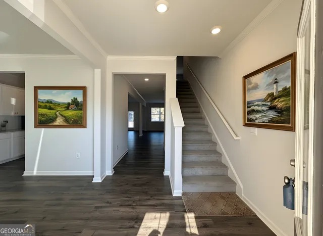 a view of a hallway with wooden floor and stairs