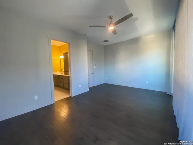 an empty room with a wooden floor and a sink