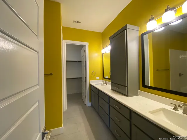 a bathroom with a double vanity sink and a mirror