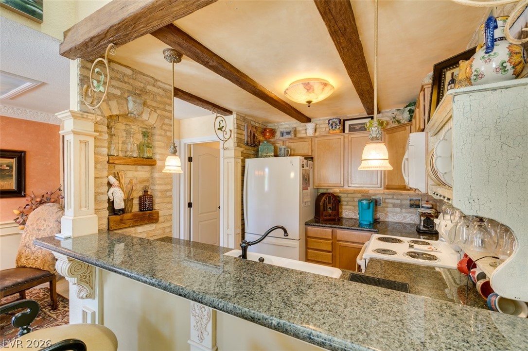 9325 West Desert Inn Road, Unit 244 Las Vegas, NV 89117 - Photo 20 of 55 A well-equipped kitchen boasts granite counters, exposed beam ceiling, and a practical layout for daily living.