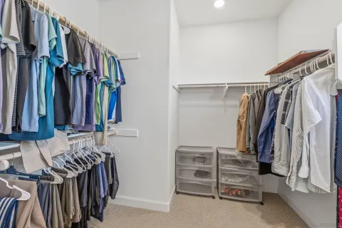 a view of walk in closet with clothes and shoes