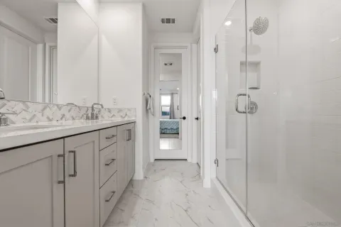 a bathroom with a granite countertop sink mirror and shower
