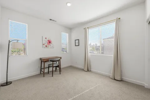 a view of an empty room with window and a kitchen