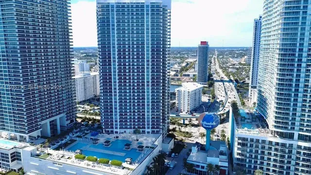 a view of a hallway with wooden floor and a bathroom