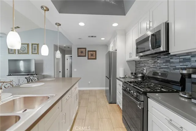 a kitchen with stainless steel appliances granite countertop a sink and a stove
