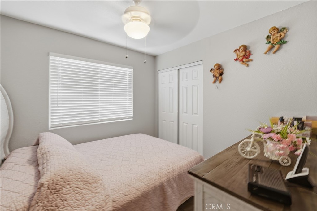 24150 Rothbury Drive Moreno Valley, CA 92553 - Photo 13 of 26 a bedroom with a bed and a table in it