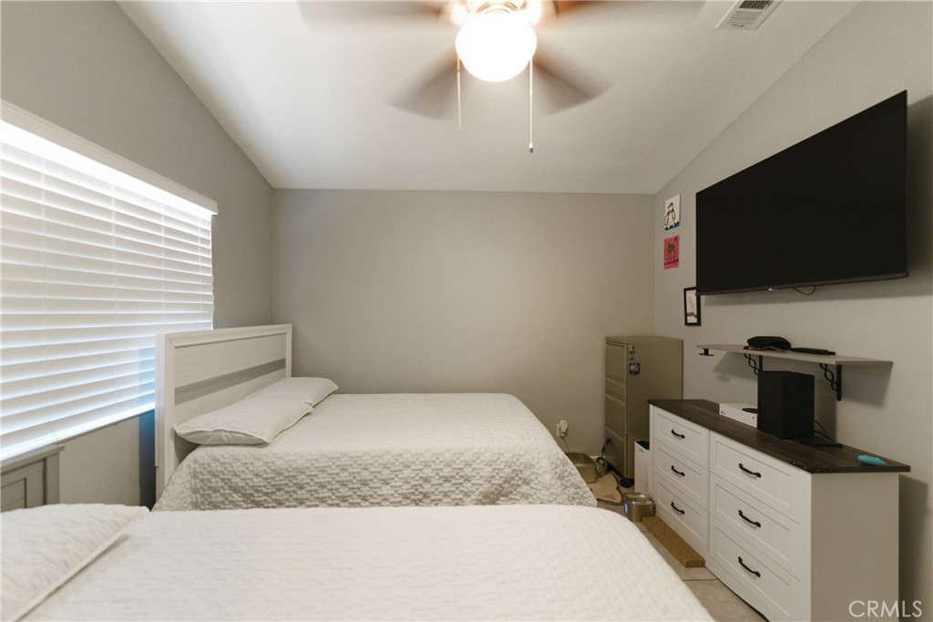 24150 Rothbury Drive Moreno Valley, CA 92553 - Photo 15 of 26 a bedroom with a bed and a flat screen tv