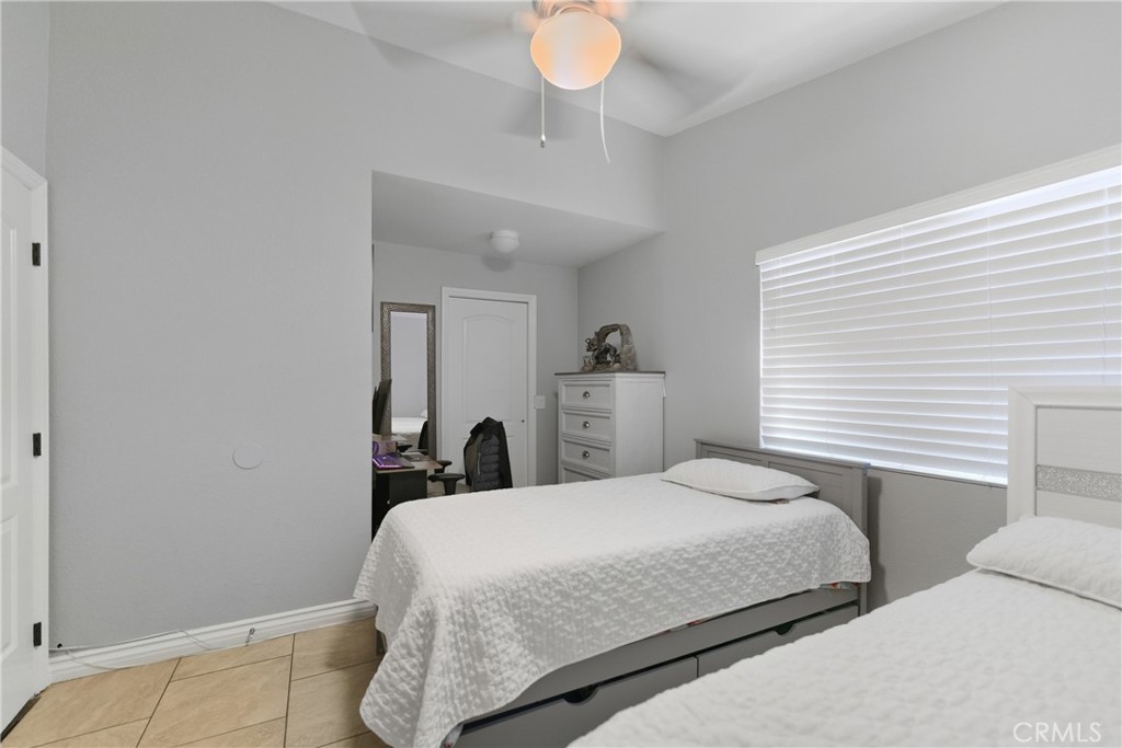 24150 Rothbury Drive Moreno Valley, CA 92553 - Photo 16 of 26 a bedroom with a bed and a chandelier