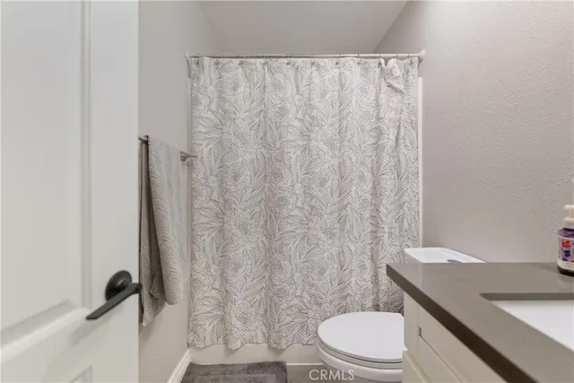 a white toilet sitting next to a shower curtain