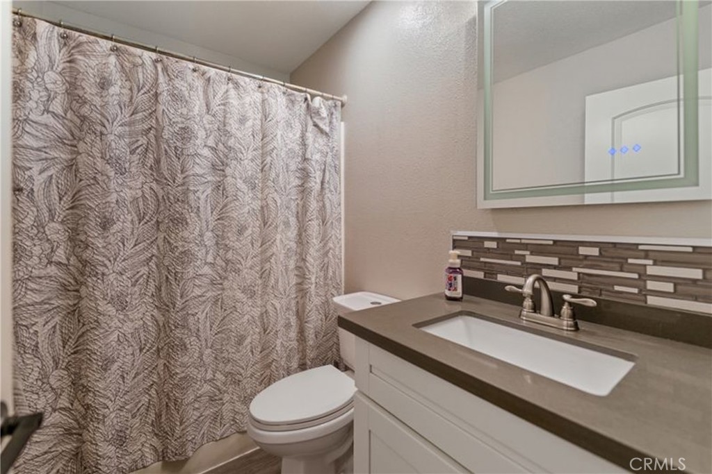24150 Rothbury Drive Moreno Valley, CA 92553 - Photo 20 of 26 a bathroom with a granite countertop sink and a toilet