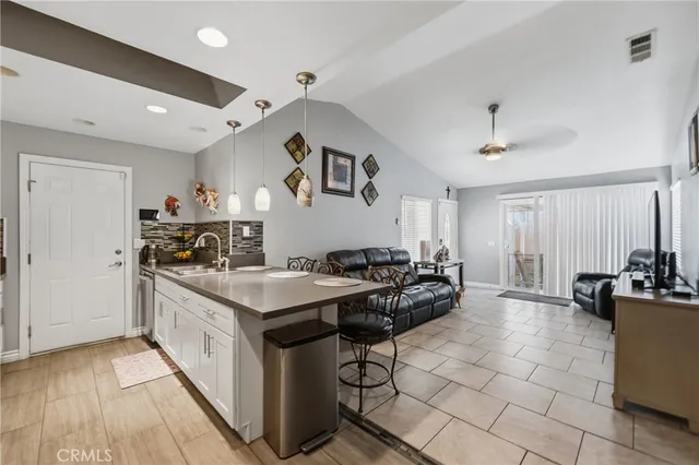 a kitchen with stainless steel appliances granite countertop a stove a sink dishwasher and a refrigerator with wooden floor