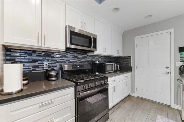 a kitchen with cabinets stainless steel appliances and a counter space