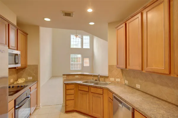 a view of a kitchen with granite countertop a sink and a window