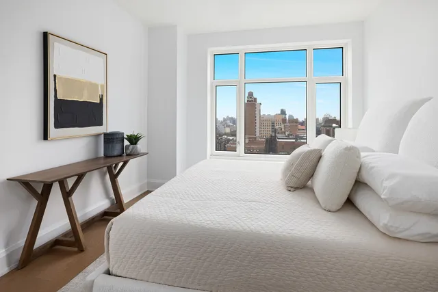 a bedroom with a bed and a large window