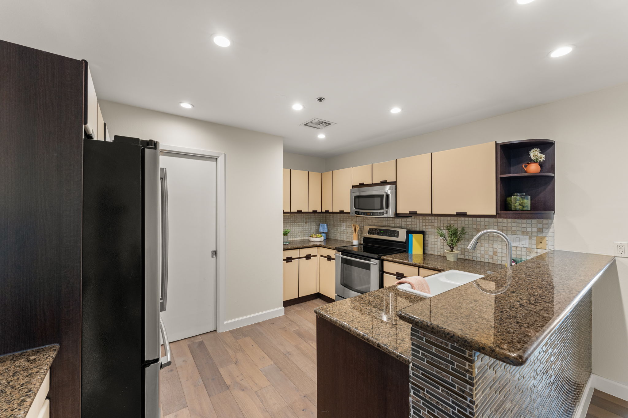 40 North Interstate Highway 35, Unit 11B2 Austin, TX 78701 - Photo 9 of 28 Granite countertops and rich wood flooring complement this well-appointed culinary space.