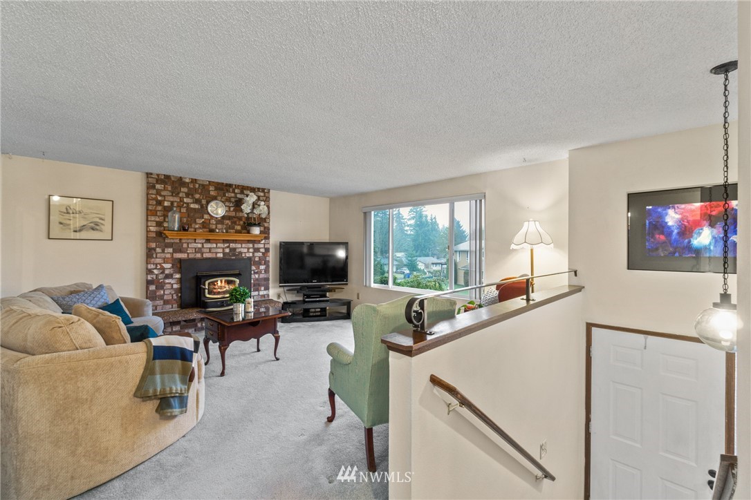 22508 3rd Place West Bothell, WA 98021 - Photo 11 of 23 a living room with furniture a flat screen tv and a floor to ceiling window