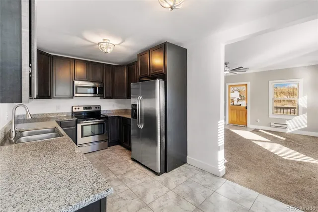 a kitchen with granite countertop a refrigerator and a sink