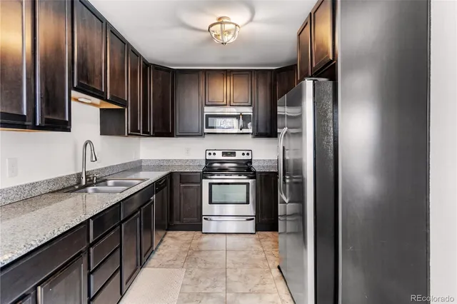 a kitchen with stainless steel appliances granite countertop a refrigerator and a sink