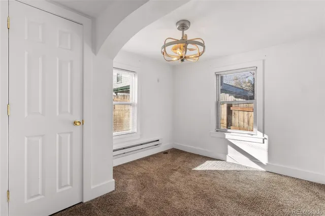 an empty room with windows and ceiling fan