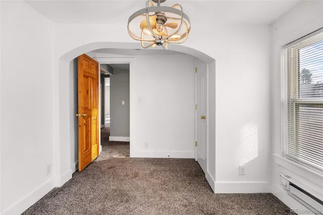 an empty room with a dining table and chandelier
