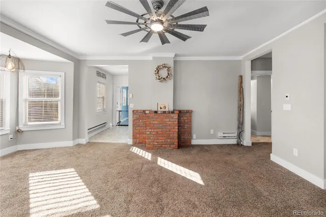 a view of a livingroom with a furniture a ceiling fan and wooden floor