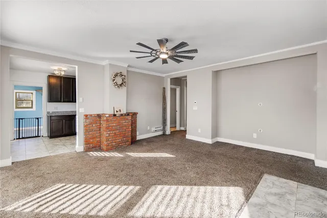a view of a livingroom with a flat screen tv ceiling fan and windows