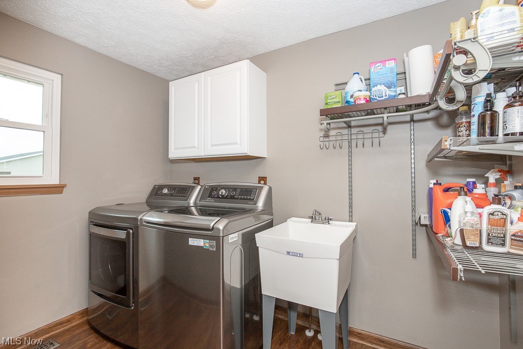 9708 Reed Road Grafton, OH 44044 - Photo 15 of 35 Laundry room with cabinets, hardwood / wood-style floors, sink, a textured ceiling, and separate washer and dryer