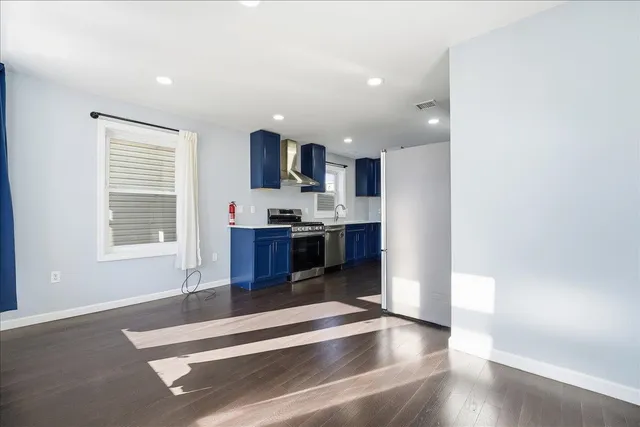 a living room with stainless steel appliances kitchen island granite countertop a stove and a view of kitchen