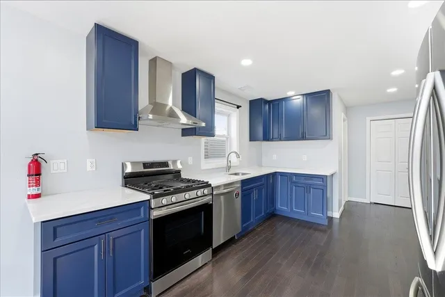 a kitchen with stainless steel appliances granite countertop a stove a sink dishwasher and a refrigerator with wooden cabinets