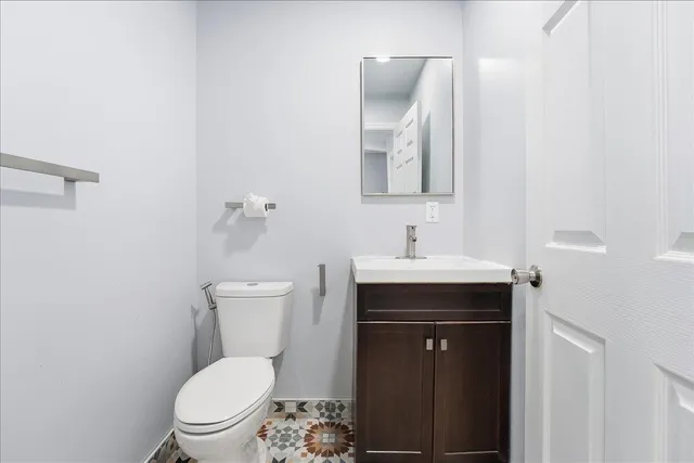 a bathroom with a toilet a sink and mirror