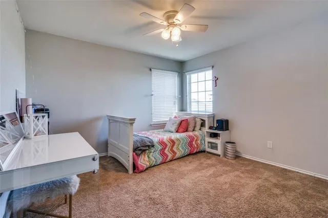 a bedroom with furniture and a chandelier fan