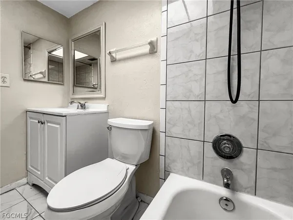 a white toilet sitting next to a bathroom sink and shower