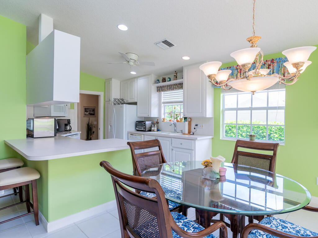 3074 Futuna Lane Naples, FL 34119 - Photo 6 of 28 a dining room with kitchen island furniture a chandelier and kitchen view