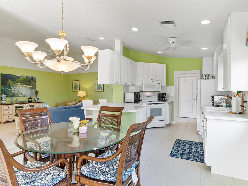 3074 Futuna Lane Naples, FL 34119 - Photo 7 of 28 a kitchen with stainless steel appliances kitchen island granite countertop a stove a refrigerator a kitchen island a dining table and chairs