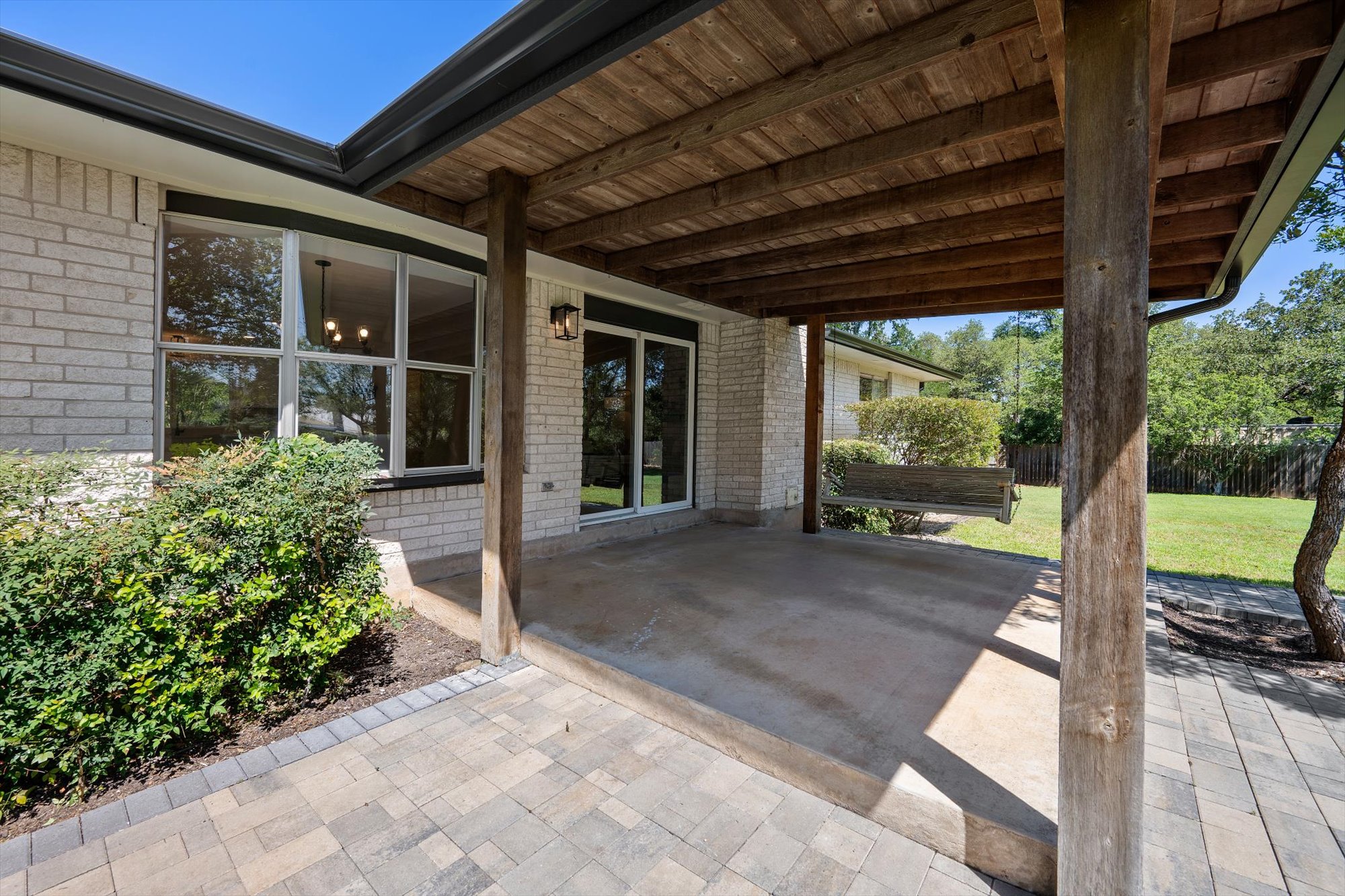 109 Woodland Road Georgetown, TX 78628 - Photo 35 of 40 A spacious covered patio with wood beam ceiling overlooks a well-maintained lawn.
