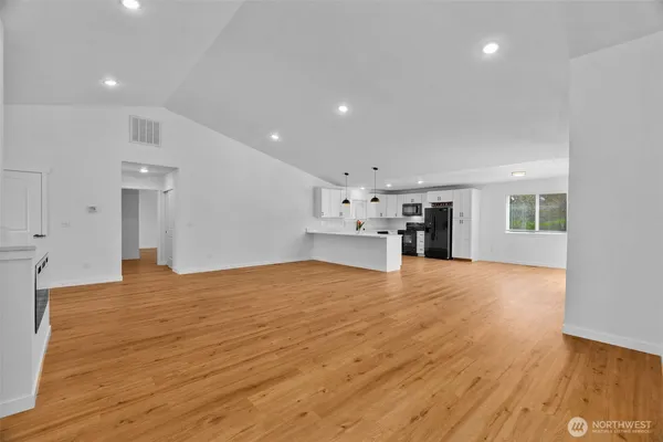 a view of empty room with wooden floor