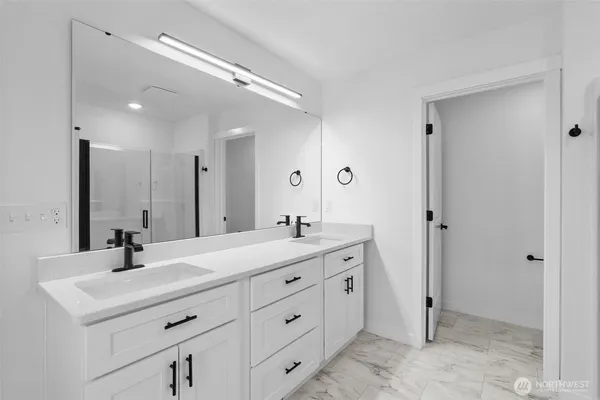 a bathroom with a double vanity sink mirror and next to a window