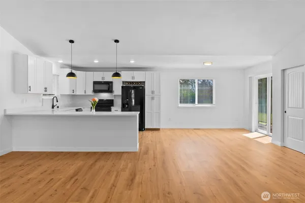 a view of kitchen with stainless steel appliances granite countertop a stove top oven a sink and a refrigerator