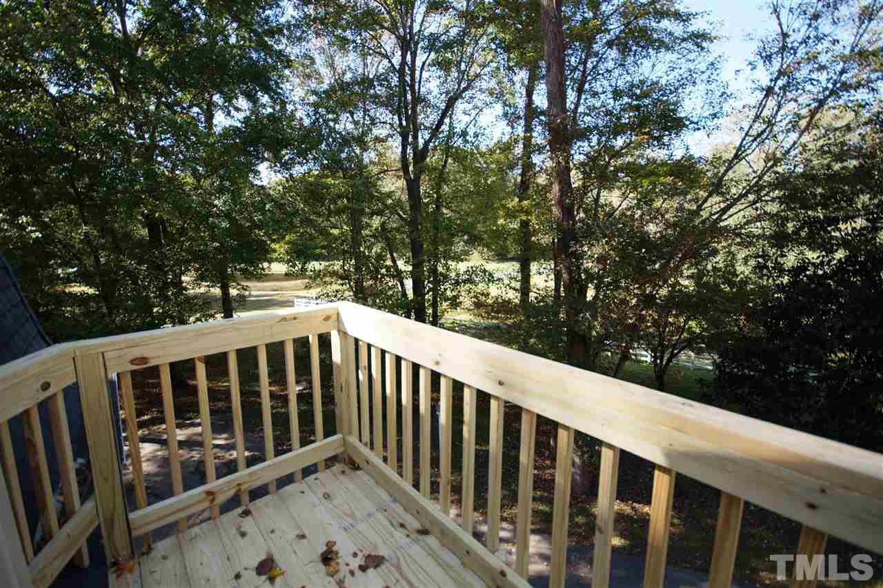 11605 Old Creedmoor Road Raleigh, NC 27613 - Photo 22 of 25 a balcony with wooden floor and trees in the back