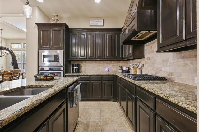 a kitchen with granite countertop stainless steel appliances and sink
