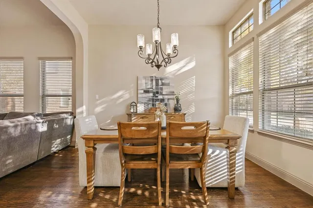 a view of a dining room with furniture a chandelier and wooden floor