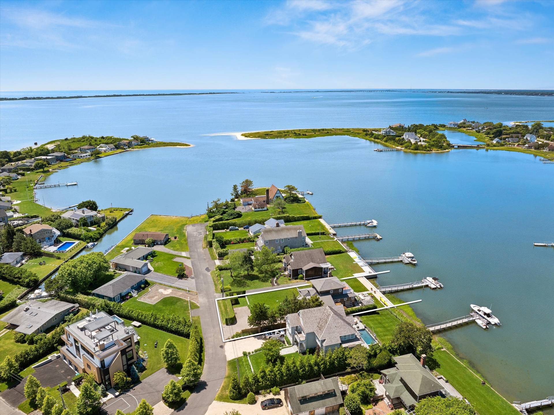 an aerial view of ocean and residential houses with outdoor space